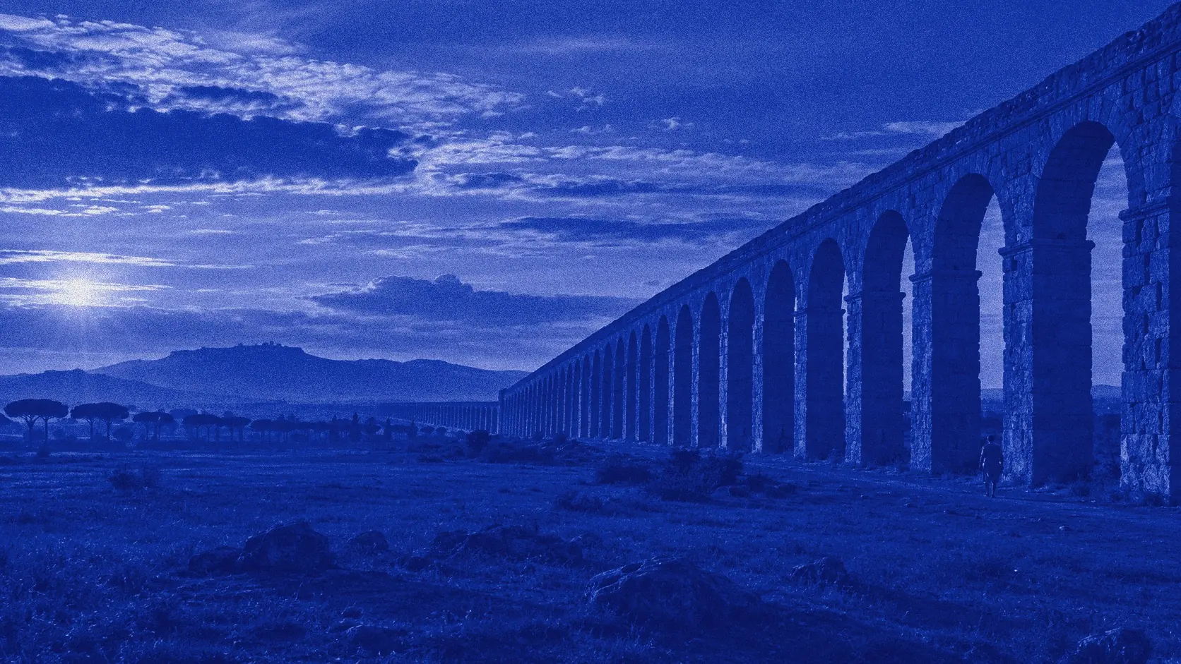 Un acueducto romano atravesando el paisaje, en duotono azul